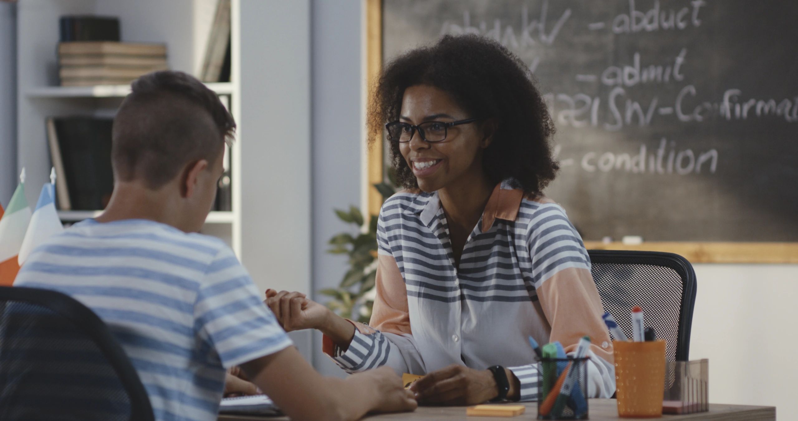 Teacher explaining to student in a classroom