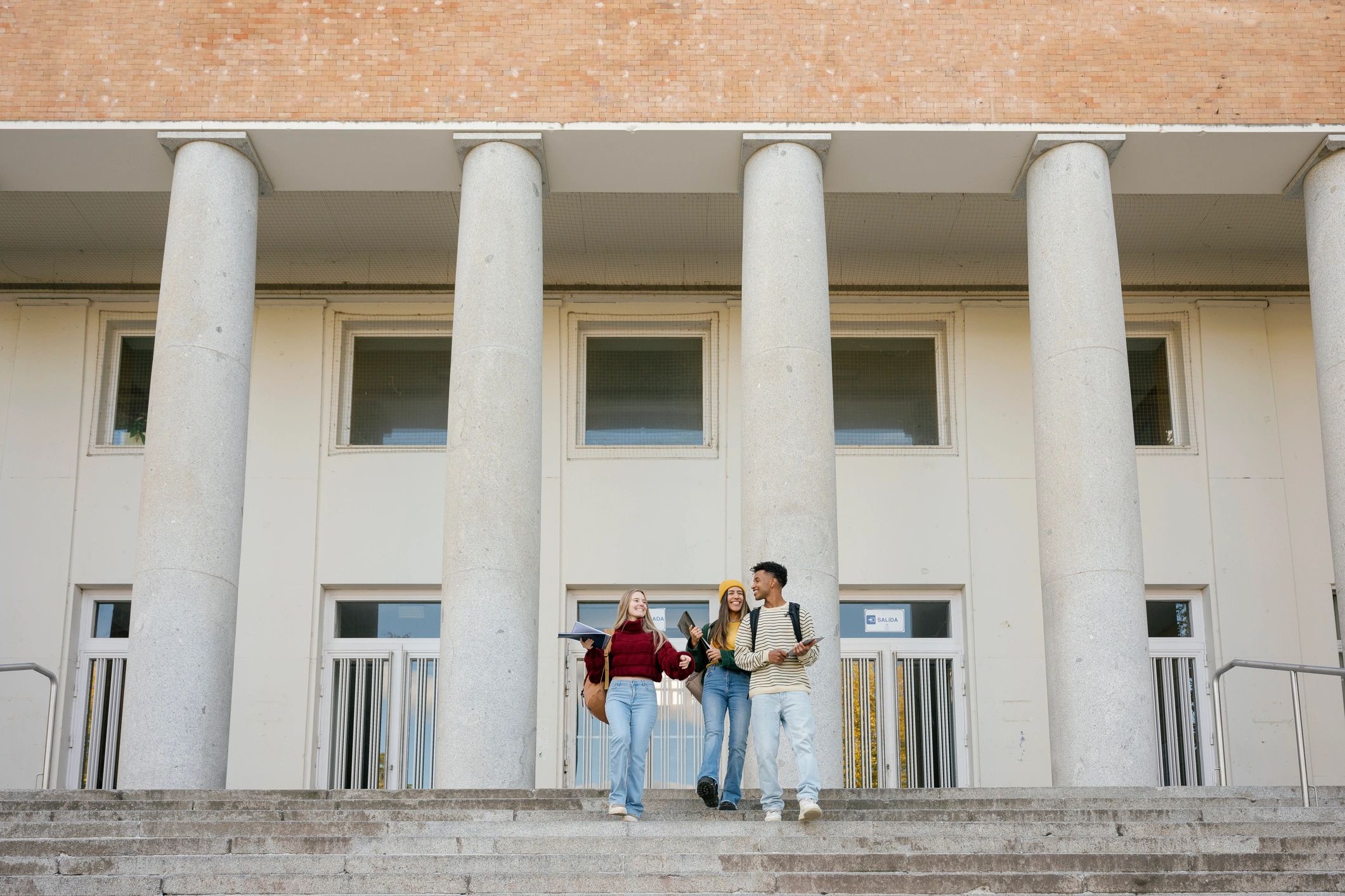 Group of diverse university students walking down campus stairs